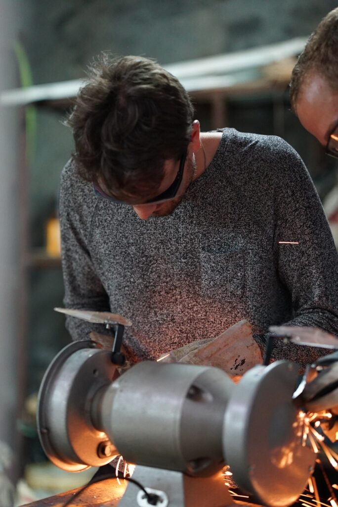 man grinding metal in workshop